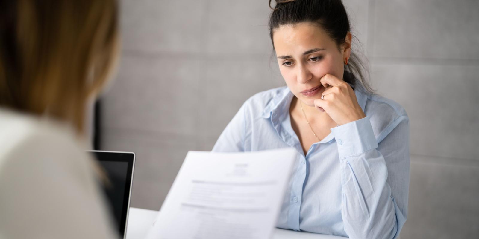 Woman worried as resume is reviewed and mistakes found.